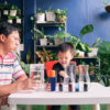Parent sitting homeschooling with little kid, Father and son having fun preparing easy science experiment
